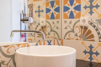 a white sink in a bathroom with colorful tiles at Panoramic luxury apartment w AC Downtown and Metro in Porto