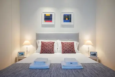 a bedroom with a large white bed with two lamps at Modern loft w AC Downtown and Metro in Porto