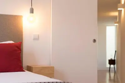 a bedroom with a bed with a red pillow at LovelyStay - Top Floor Balcony Apartment in Porto
