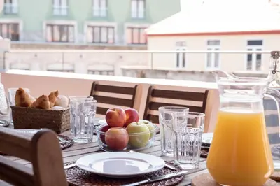 a table with a bowl of apples and a glass of orange juice at LovelyStay - Top Floor Balcony Apartment in Porto