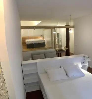 a bedroom with a white bed and a mirror at Goabio apartments 2 river view in Porto