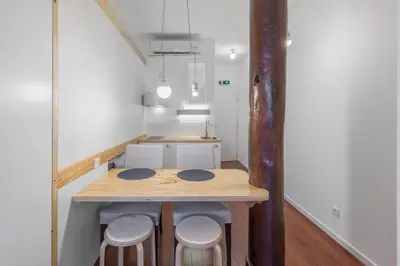 a small kitchen with a wooden table and stools at Goabio apartments 2 river view in Porto
