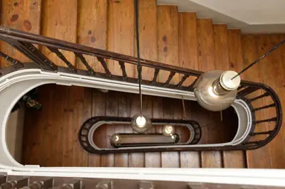 a spiral staircase with a pipe and lights at Pensao Favorita in Porto