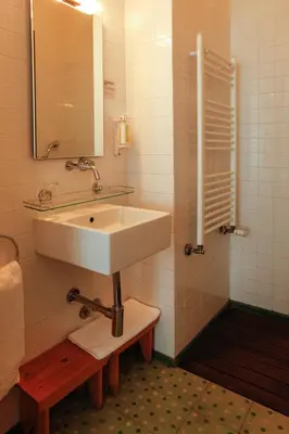 a white bathroom with a sink and a shower at Pensao Favorita in Porto