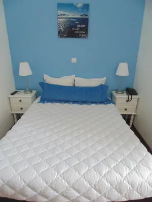 a bedroom with a large white bed with blue walls at Hotel Porto Rico in Porto