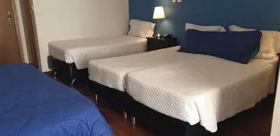 two beds in a room with blue walls at Hotel Porto Rico in Porto