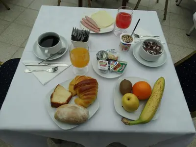 a white table with a plate of breakfast foods and drinks at Hotel Porto Rico in Porto