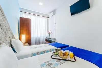 a hotel room with a tray of food on a bed at Santa Clara Porto in Porto