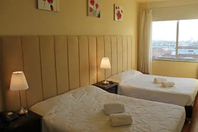 a hotel room with two beds and a window at Santa Clara Porto in Porto