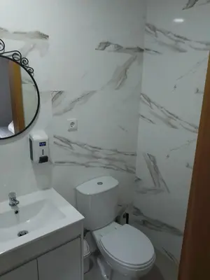a white bathroom with a toilet and a sink at Guest house D. Filipe I in Porto