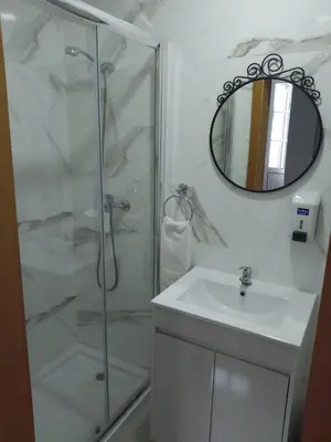 a bathroom with a shower and a sink and a mirror at Guest house D. Filipe I in Porto