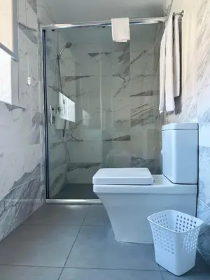 a bathroom with a toilet and a glass shower at Guest house D. Filipe I in Porto