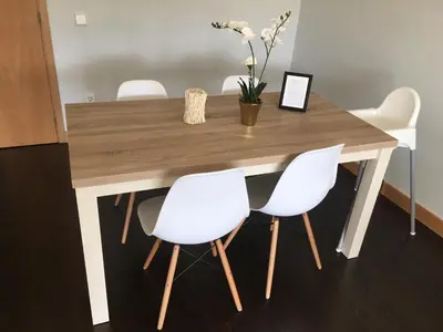 a wooden table with four white chairs and a table with ahibition at Porta do Sol in Porto