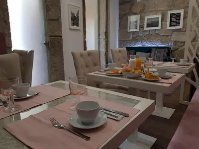 a dining room with a table with plates of food at 22 Oporto Guesthouse in Porto