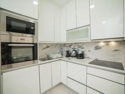 a white kitchen with white cabinets and a microwave at OPORTO GUEST Amparo Dollhouse in Porto