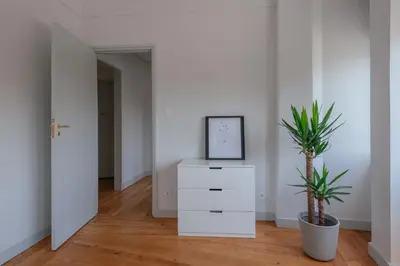 a white room with a white dresser and a plant at Baixa24 - Downtown Bliss w/ Amazing Natural Light in Porto