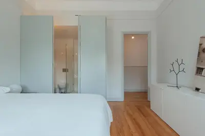 a bedroom with a white bed and a glass shower at Baixa24 - Downtown Bliss w/ Amazing Natural Light in Porto