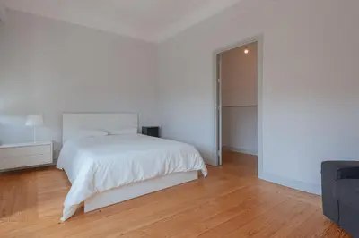 a white bedroom with a bed and a sliding door at Baixa24 - Downtown Bliss w/ Amazing Natural Light in Porto