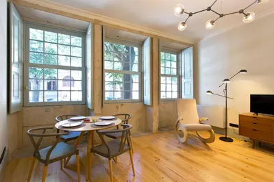 a dining room with a table and chairs and windows at Trait House in Porto