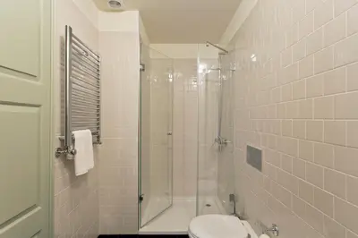 a bathroom with a toilet and a glass shower at Trait House in Porto