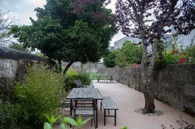 a picnic table and benches in a garden at Trait House in Porto