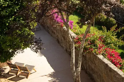a pathway with two chairs and flowers in a garden at Trait House in Porto