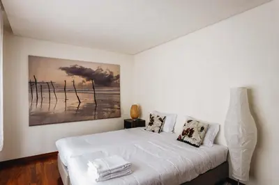 a bedroom with a bed with a painting on the wall at Premium Apartment with Private Terrace & Garage in Porto