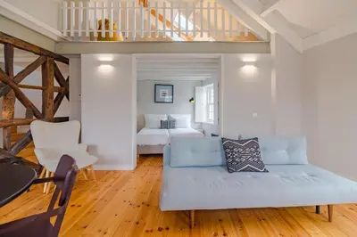 a living room with a couch and a bed at YOUROPO - City Center Ribeira Porto in Porto