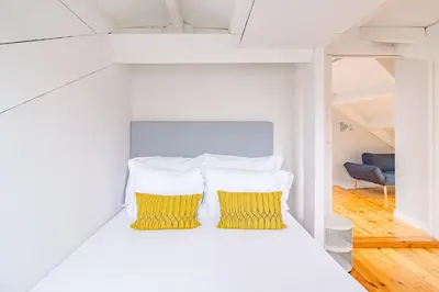 a bedroom with two yellow pillows on a bed at YOUROPO - City Center Ribeira Porto in Porto