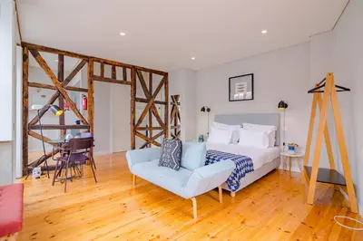 a bedroom with a bed and a chair and a table at YOUROPO - City Center Ribeira Porto in Porto