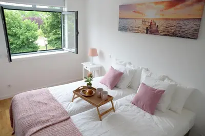 a bedroom with a white bed with a table on it at Porto Smart Apartments - Downtown in Porto