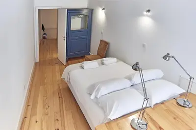 a bedroom with two beds and a blue door at PortoSense Almada in Porto
