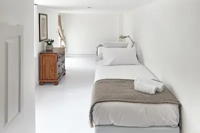 a bedroom with two beds and a wooden table at PortoSense Almada in Porto
