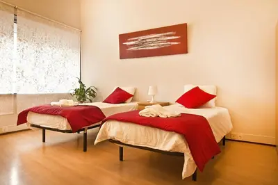 two beds with red pillows in a room at VRS - Porto Centre Trindade Studio in Porto