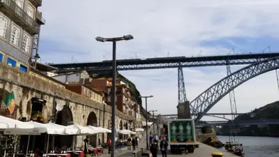 a bridge over a river with a bridge in the background at VRS - Porto Centre Trindade Studio in Porto