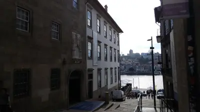 a narrow street with buildings next to a river at VRS - Porto Centre Trindade Studio in Porto