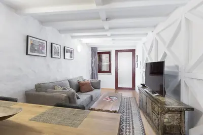a living room with a couch and a tv at VIVA Caldeireiros Porto Old Town in Porto