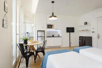 a hotel room with two beds and a refrigerator at Galerias Nightlife Fashion Flats in Porto