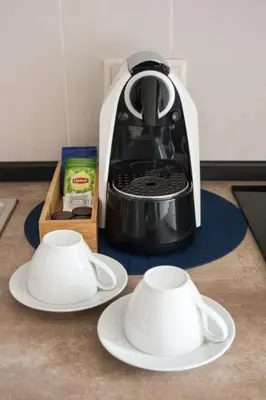 a black and white coffee maker and two white plates at Nations Porto - Studios & Suites in Porto