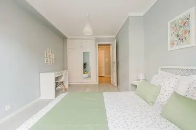 a white bedroom with a bed and a fireplace at Lima House in Porto