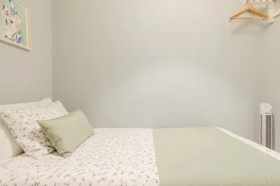 a white bedroom with a bed with a pillow at Lima House in Porto