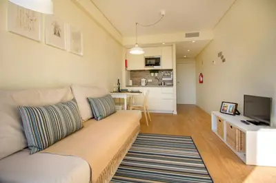 a living room with a couch and a kitchen at Green Suite in Porto