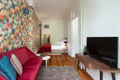 a living room with a red couch and a bedroom at Predicados do Douro Palace in Porto