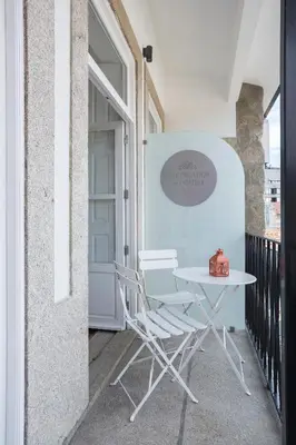 a white table and chair on a balcony at Predicados do Douro Palace in Porto