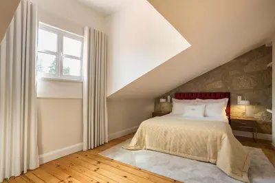 a bedroom with a bed and a window at Predicados do Douro Palace in Porto