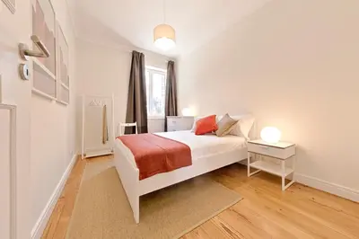 a white bedroom with a bed and a window at Sleep in Centre in Porto