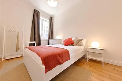 a white bedroom with a bed and a window at Sleep in Centre Downtown in Porto