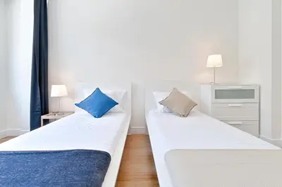 two beds in a room with two blue pillows at Sleep in Centre Downtown in Porto