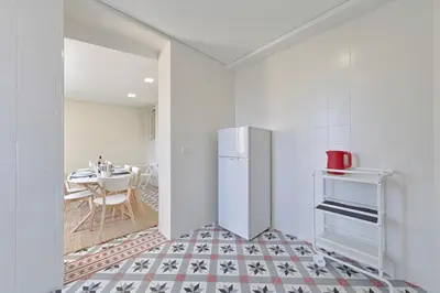 a kitchen with a refrigerator and a table at Sleep in Centre Downtown in Porto