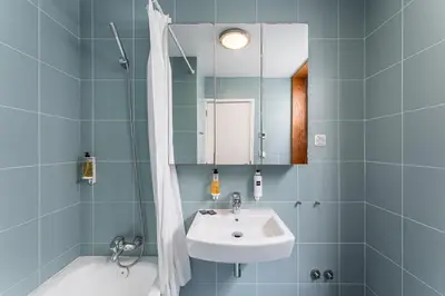 a bathroom with a sink and a mirror and a tub at GuestReady - Cosy studio in the heart of Porto in Porto
